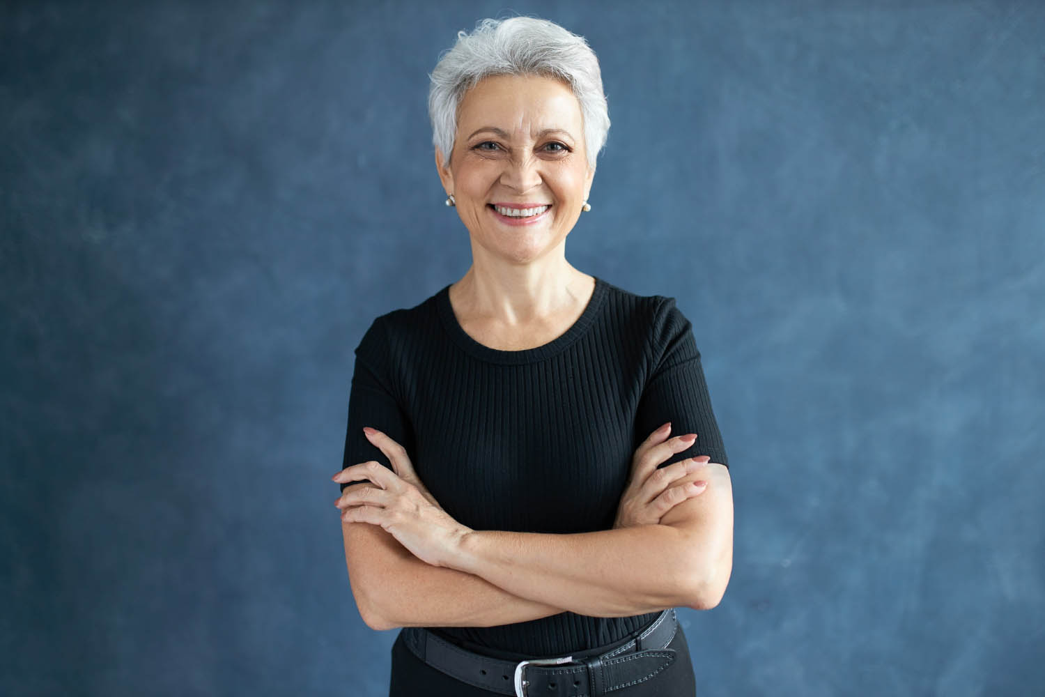 tudio shot beautiful happy retired caucasian female with pixie hairdo crossing arms her chest having confident look smiling broadly